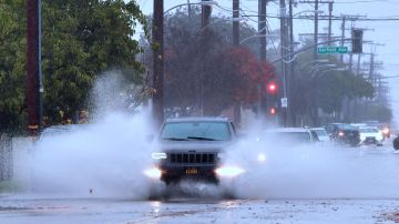 Vehículos se abren paso en medio de calles inundadas en Monterey Park.