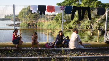 Inmigrantes hondureños durante la segunda caravana migrante cruzan el puente internacional entre Guatemala y México.