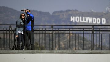 Turistas toman fotos al frente del icónico letrero de Hollywood.