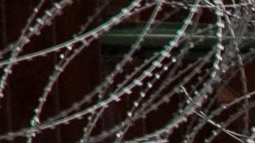 La foto muestra una alta valla reforzada con alambre de púas en Nogales. Robert Bushell/CBP