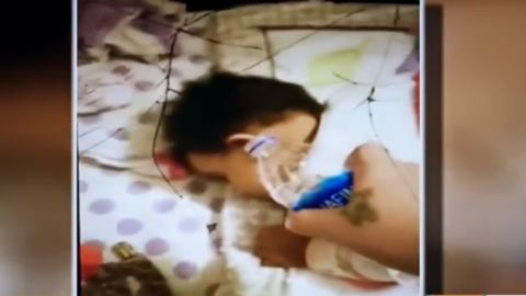 Mamá echa agua a bebé mientras duerme