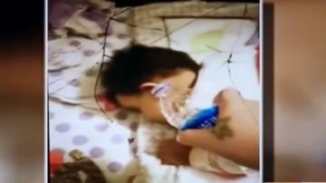 Mamá echa agua a bebé mientras duerme