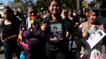 Shirley Palencia (c) con una foto de su hermana  Kimberly Mishel, quien murió en el incendio, en el funeral el 17 de marzo de 2017.