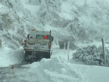 Trabajadores se encuentran despejando la nieve en la zona de las montañas de Chilao en la autopista Crest de Los Ángeles.