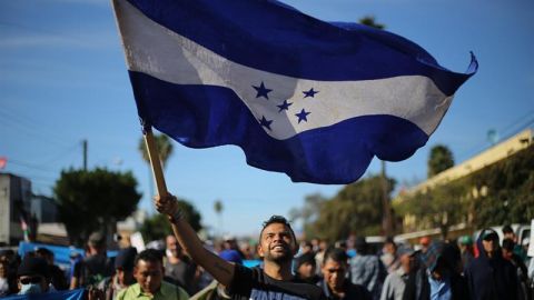 Miembros de una de las caravanas migrantes. En primer plano, portan la bandera de Honduras.