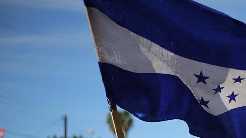 Miembros de una de las caravanas migrantes. En primer plano,  portan la bandera de Honduras.