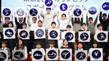 Atletas y estudiantes japoneses exhiben los pictogramas deportivos de Tokio 2020.