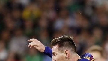 El delantero argentino del FC Barcelona, Lionel Messi deja atrás a los jugadores del Real Betis.
