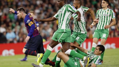 El delantero argentino del FC Barcelona, Lionel Messi deja atrás a los jugadores del Real Betis.