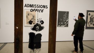 Un visitante fotografía cerca de la obra de arte 'The Door (Oficina de Admisiones)' de David Hammons, parte de la exposición 'Alma de una nación: El arte en la era del poder negro 1963-1983'. (EFE/ Eugene García)