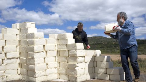 El artista canadiense Cosimo Cavallaro (d) levanta un muro de queso junto a su amigo el artista Carlo Arcesi (i)  a pocos pasos de la barda que separa Estados Unidos y México en Tecate, California. EFE/David Maung