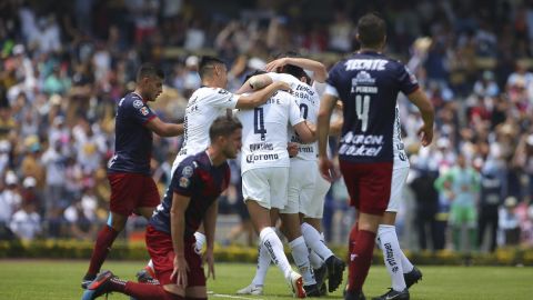 Jugadores de Pumas festejan mientras los de Chivas se lamentan en la cancha de CU.