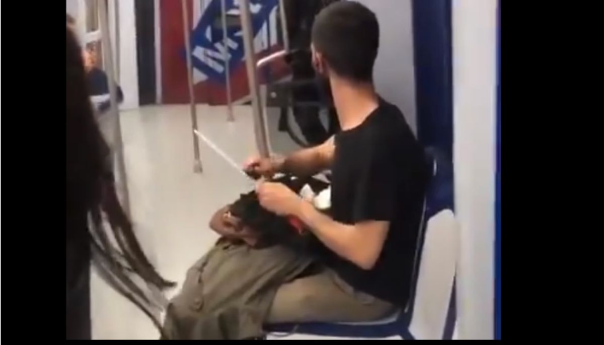Un usuario de Metro de Madrid afila un cuchillo en el tren.