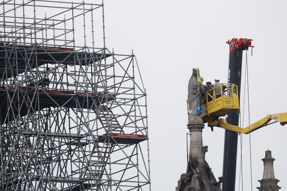 Operarios protegen una estatua de la catedral de Notre Dame una vez extinguido el incendio.