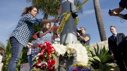 Varias personas dejan flores frente a la sinagoga atacada en Poway, el 27 de abril de 2019.