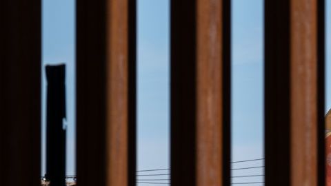 Un globo satírico de un bebé del presidente de los Estados Unidos, Donald Trump, es visto a través de la valla fronteriza entre Estados Unidos y México durante una manifestación contra él durante su visita a Calexico.