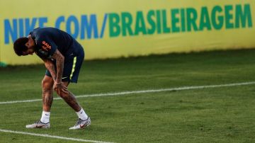 El futbolista brasileño Neymar toca su rodilla izquierda durante el entrenamiento de la selección brasileña.