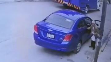 El hombre lleva una bolsa de ropa en la mano.