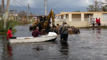Residentes de Beaumont, Texas, usan un pequeño barco para subir al techo de su casa inundada después de que el huracán Harvey dejara inundaciones severas en el área en agosto 31 de 2017. Yuisa Rios/FEMA