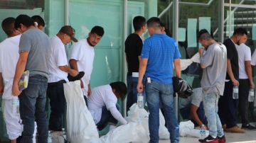 Migrantes deportados colocan sus pertenencias en bolsas, en Matamoros.