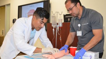 Harvey Peralta, 26, (izq.) practica como poner inyecciones en el programa de verano HCOP de AltaMed y la Universidad Charles Drew. (Suministrada)