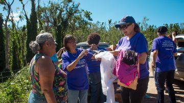 Voluntarios de la iglesia Metodista Villas de Loíza entregan ropa y artículos esenciales a sobrevivientes en la comunidad Don Alonzo. Los artículos fueron proporcionados por FEMA y otras organizaciones sin fines de lucro.(FEMA/Eduardo Martínez)