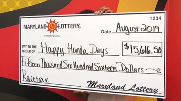 "Happy Honda Days" sostiene el cheque de su premio de lotería.