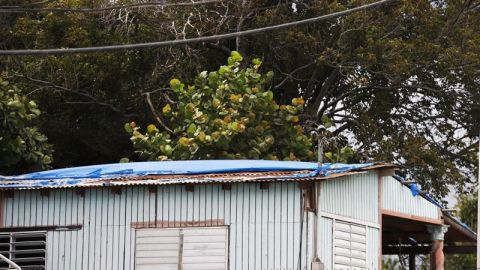 Una casa rústica con toldo azul sobre el techo para protección en Ponce, en la costa sur de Puerto Rico.