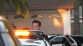 Un policía sostiene en sus brazos al bebe quien se encuentra bajo custodia de las autoridades.