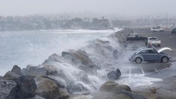 Las olas de una marea real en diciembre de 2018 llegan a un parqueo en Cabrillo Beach, California.