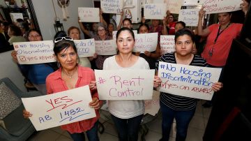 Inés Feijo, María Vega y Katherine Álvarez protestan los aumentos de la renta en Downey. (Aurelia Ventura/La Opinión)