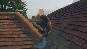 Un hombre defeca en el tejado.