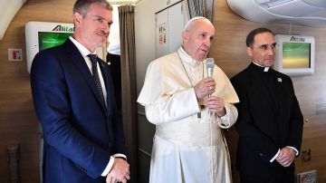 El papa Francisco responde a periodistas en su avión.