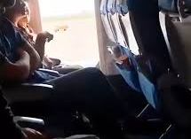 Una mujer abre la puerta de emergencia durante un vuelo.