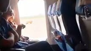 Una mujer abre la puerta de emergencia durante un vuelo.