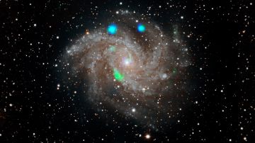 Imagen de la galaxia Fireworks (NGC 6946) del Digital Sky Survey, con datos del observatorio NuSTAR (en azul y verde).