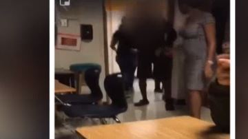 En las imágenes se observa el momento en el que la maestra se le acerca a un alumno con unas tijeras.