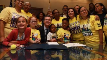 Acompañado de cuidadores de niños y algunos menores, el gobernador Newsom firmó ayer la medida AB 378. (Suministrada)