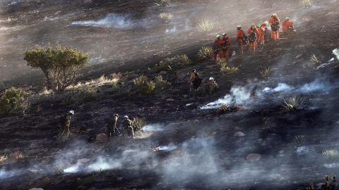 Bomberos apagan las brasas del Tick Fire en una colina de Agua Dulce cerca de Santa Clarita.