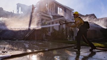 Bomberos apagan el fuego en una casa cerca de Santa Clarita en California. EFE