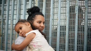 Remesme Marián es abrazada por su madre junto al muro fronterizo. (Manuel Ocaño).