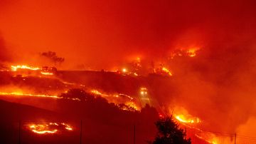 Bomberos recorren las carreteras rodeadas de fuego por el incendio de Kincade cerca de Geyserville, California.