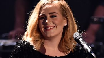 Adele sonriendo en un concierto.