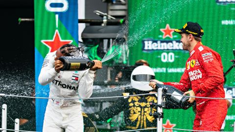 Lewis Hamilton festeja con Sebastian Vettel. Al fondo se aprecia Mario Achi.