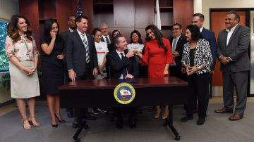 El gobernador de California Gavin Newsom celebra la firma de la ley AB 539 junto a la asambleista Monique Limón y un grupo de activistas. (Suministrada)