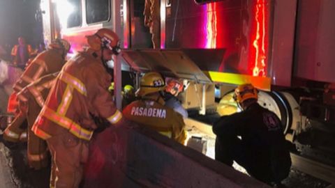 El Departamento de Bomberos de Pasadena trabaja para sacar a una persona atrapada debajo del tren.