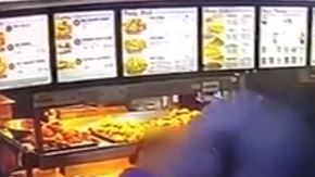 Los sospechosos encapuchados fueron grabados en video de vigilancia brincando sobre el mostrador para atacar a los empelados.