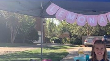 Las niñas venden limonada y otros productos para recaudar fondos.