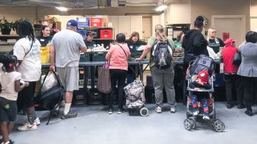 Personas reciben sus alimentos en un banco de comida en California. /Foto: Jackie Botts de CalMatters.
