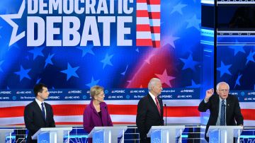 Pete Buttigieg, Elizabeth Warren  y Joe Biden escuchan a Bernie Sanders.